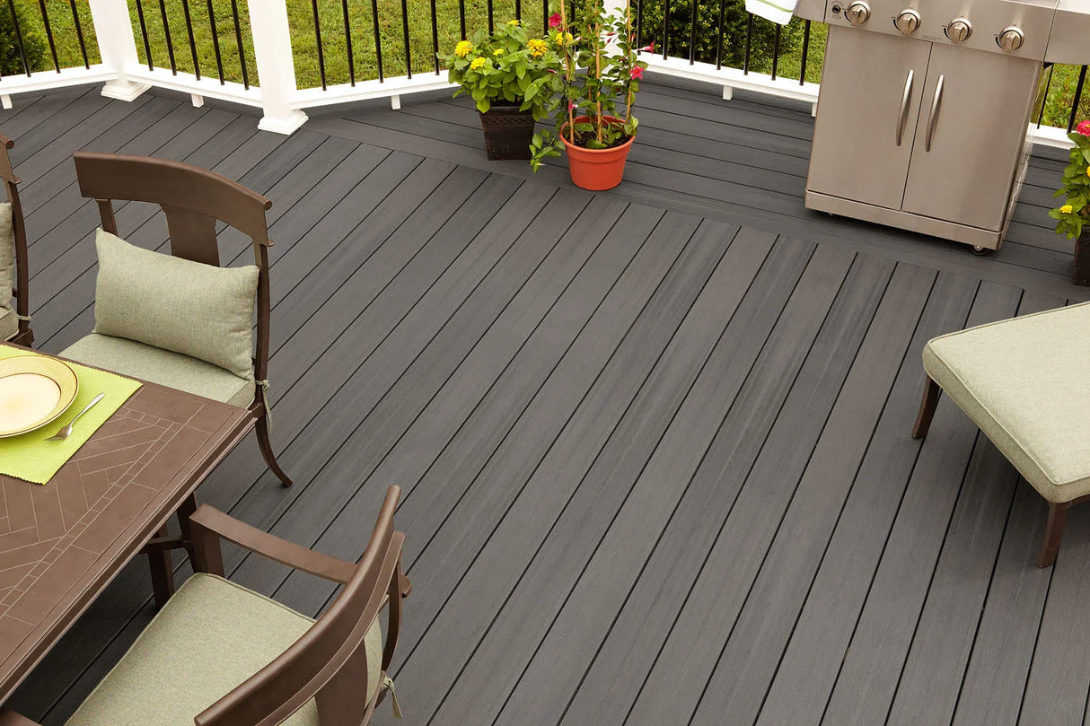 Terrasse en bois composite gris ardoise avec mobilier de jardin, plantes et barbecue