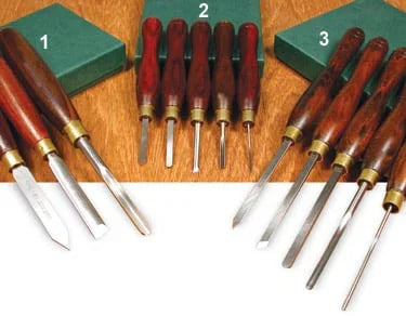 Ensemble de ciseaux à bois pour ébénisterie avec manches en bois, posés sur une table.