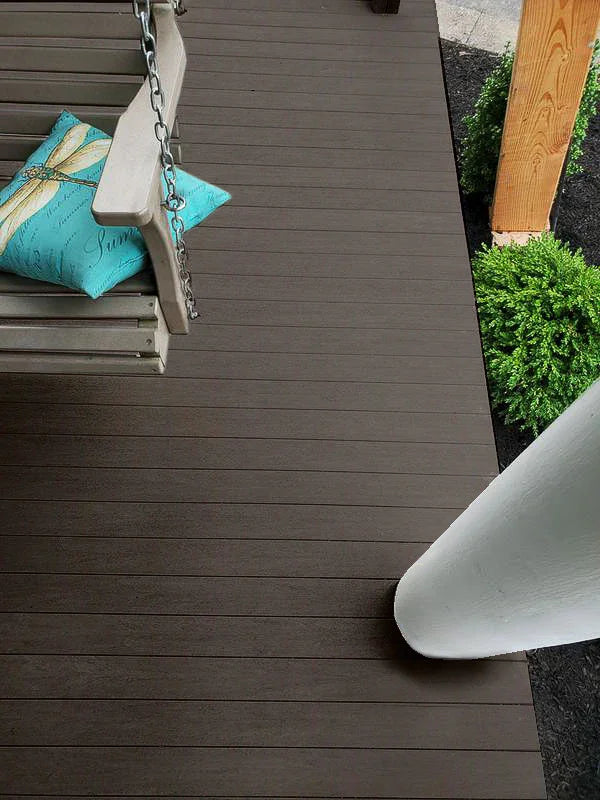 Plancher de terrasse en composite gris foncé, balancelle et coussin turquoise, poteau blanc