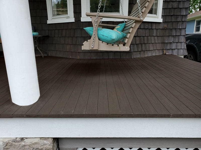 Terrasse en bois composite foncé avec planches rainurées et balançoire suspendue
