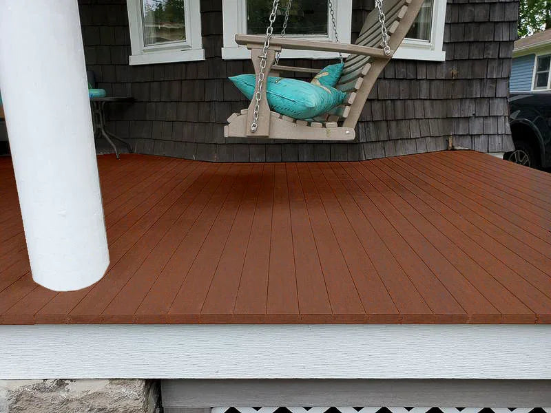 Terrasse en bois composite brun avec planches rainurées devant une maison et une balançoire
