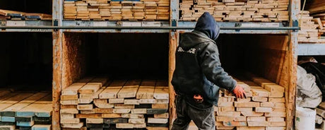 Homme choisissant des planches de bois brut dans un entrepôt à Montréal