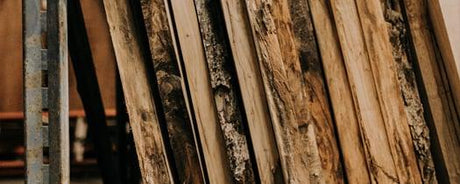 Planches de bois brut variées en exposition, essences indigènes et exotiques pour ébénisterie