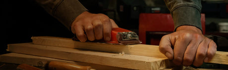 Ponçage de planches de bois avec une cale à poncer, atelier d'ébénisterie bois.