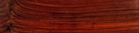 Surface de bois Cocobolo exotique, grain marqué et teintes rouges pour ébénisterie.