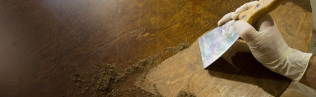 Décapage de surface en bois avec une spatule, restauration meuble, finition ébénisterie