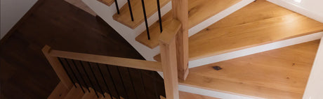 Escalier intérieur moderne en bois massif avec garde-corps noir, éclairage naturel