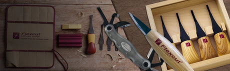 Ensemble d’outils de sculpture sur bois Flexcut, couteaux et accessoires sur table en bois.