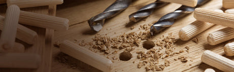 Goujons en bois et mèches de perceuse sur planche pour assemblage d'ébénisterie