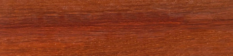 Gros plan sur surface de bois exotique padouk, texture et grain rouge-brun naturel