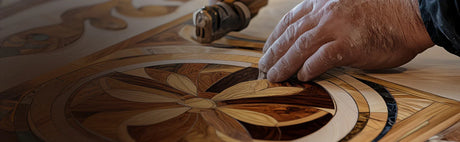 Main travaillant sur une marqueterie florale en bois, artisanat, placage détaillé