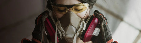 Femme en équipement de sécurité avec masque, lunettes et gants pour travail du bois