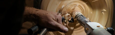 Main de menuisier travaillant le bois au tour, copeaux, ébénisterie, bois massif