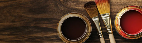 Pots de teinture pour bois et pinceaux sur une surface en bois sombre, produits d'ébénisterie