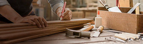 Ébéniste mesurant des planches de bois, outils et boîte à outils sur un établi, atelier menuiserie