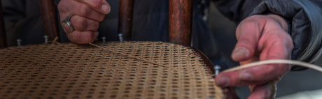 Tressage artisanal d’une assise de chaise en rotin, travail de vannerie traditionnel