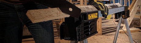 Découpe d'une planche de bois avec une scie à main sur chevalet DeWalt, atelier menuiserie.