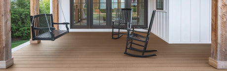 Terrasse en composite aspect bois avec banc suspendu et fauteuils à bascule noirs