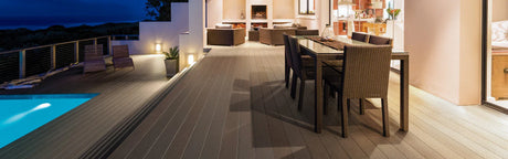 Terrasse en composite gris avec salon de jardin et piscine, éclairage extérieur moderne