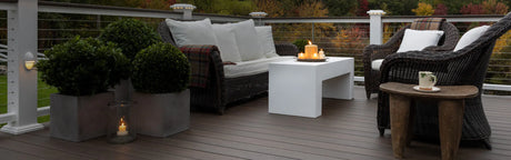 Terrasse en bois composite Mocha avec mobilier extérieur, plantes et bougies, ambiance chaleureuse.