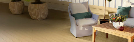 Terrasse extérieure en composite chêne blanchi, fauteuil, table basse en bois, plantes décoratives