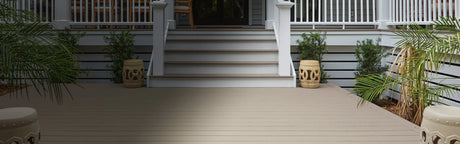 Terrasse en composite gris clair avec escalier, plantes et balustrade blanche, extérieur moderne