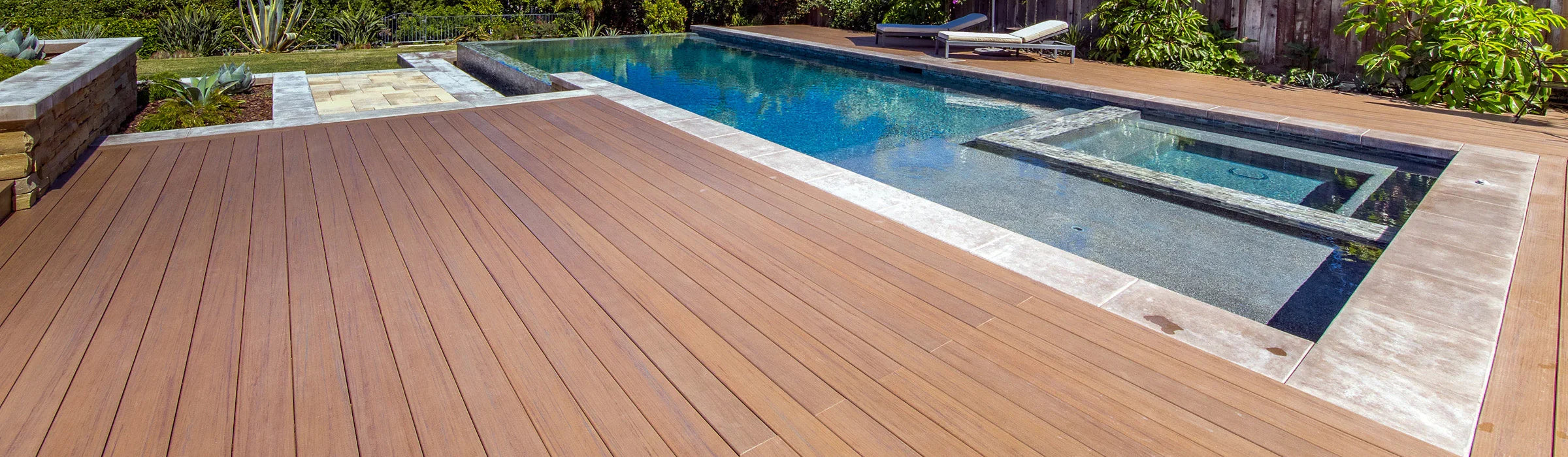 Terrasse en composite brun autour d'une piscine moderne, idéale pour l'aménagement extérieur