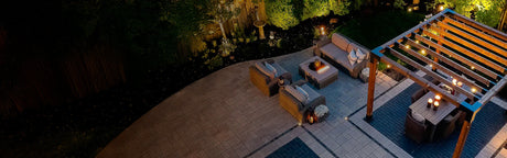 Terrasse moderne aménagée avec pergola en bois, mobilier d'extérieur et éclairage nocturne.