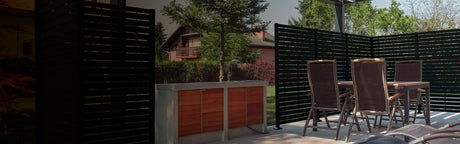 Terrasse extérieure avec panneaux en bois, mobilier de jardin et évier sous une pergola