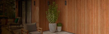 Terrasse moderne avec mur en bois, fauteuils extérieurs et plantes en pots, ambiance chaleureuse