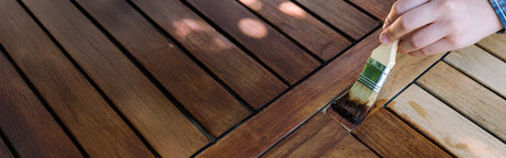Application de vernis sur lames de bois pour terrasse extérieure, protection du bois.