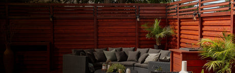 Terrasse en bois exotique aménagée avec canapé d'extérieur et plantes vertes