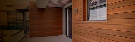 Terrasse moderne avec bardage bois exotique et porte vitrée, parfaite pour l'extérieur