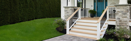 Entrée de maison avec terrasse en bois, marches et rampes modernes, jardin paysager