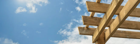 Structure en bois massif pour terrasse extérieure sous ciel bleu avec nuages