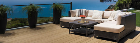 Terrasse en PVC aspect teck vieilli avec salon extérieur, vue sur la mer, plantes vertes en pots