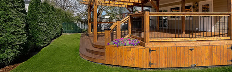 Terrasse en bois extérieur avec balustrades en métal fini, pergola et jardinière fleurie