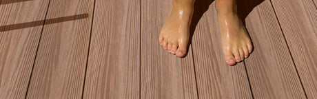 Pieds mouillés sur terrasse extérieure en bois composite couleur châtaignier cèdre