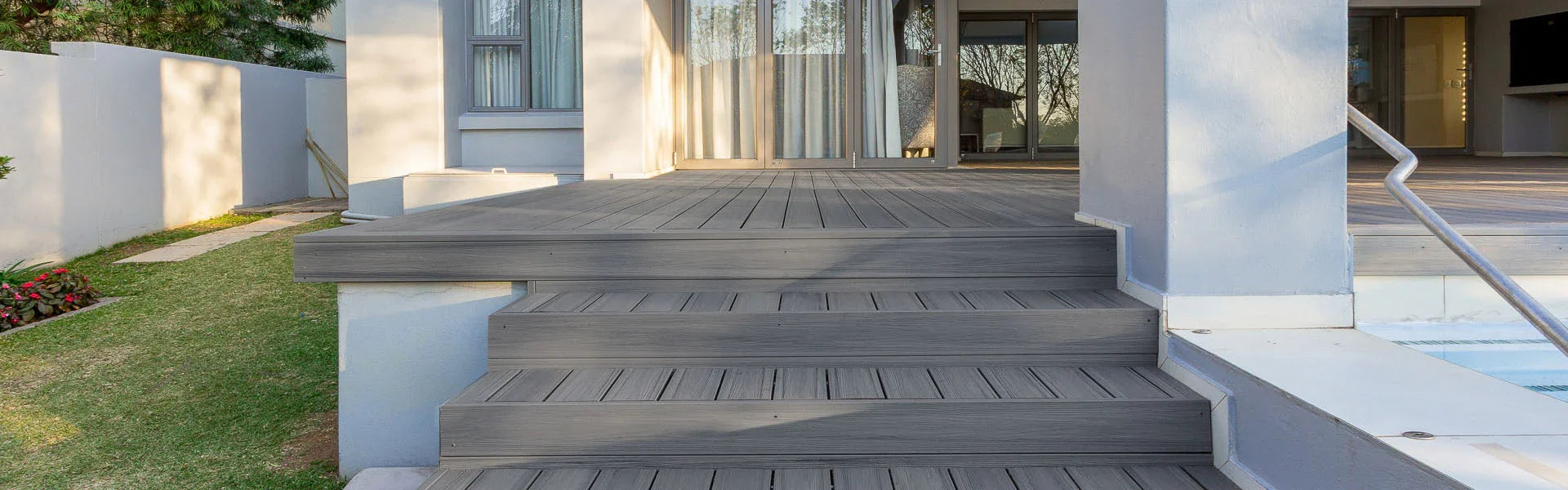 Terrasse en composite gris avec marches, devant une maison moderne, idéale pour l'extérieur