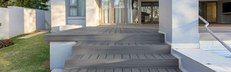 Terrasse en composite gris avec marches, devant une maison moderne, idéale pour l'extérieur