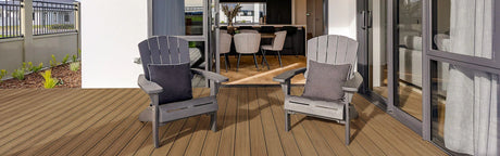 Terrasse en bois composite avec deux fauteuils gris devant une maison moderne