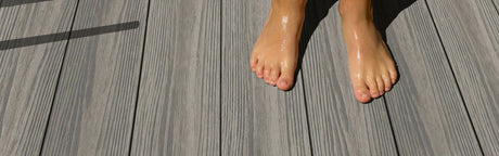 Pieds nus sur terrasse composite gris effet bois, lames antidérapantes extérieures