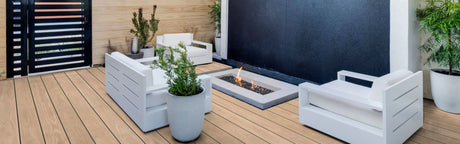 Terrasse extérieure avec lames de terrasse aspect bois, mobilier moderne blanc et foyer central