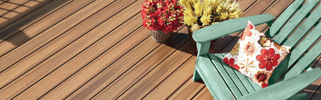 Plancher de terrasse composite brun, fauteuil vert, fleurs et coussin décoratif extérieur