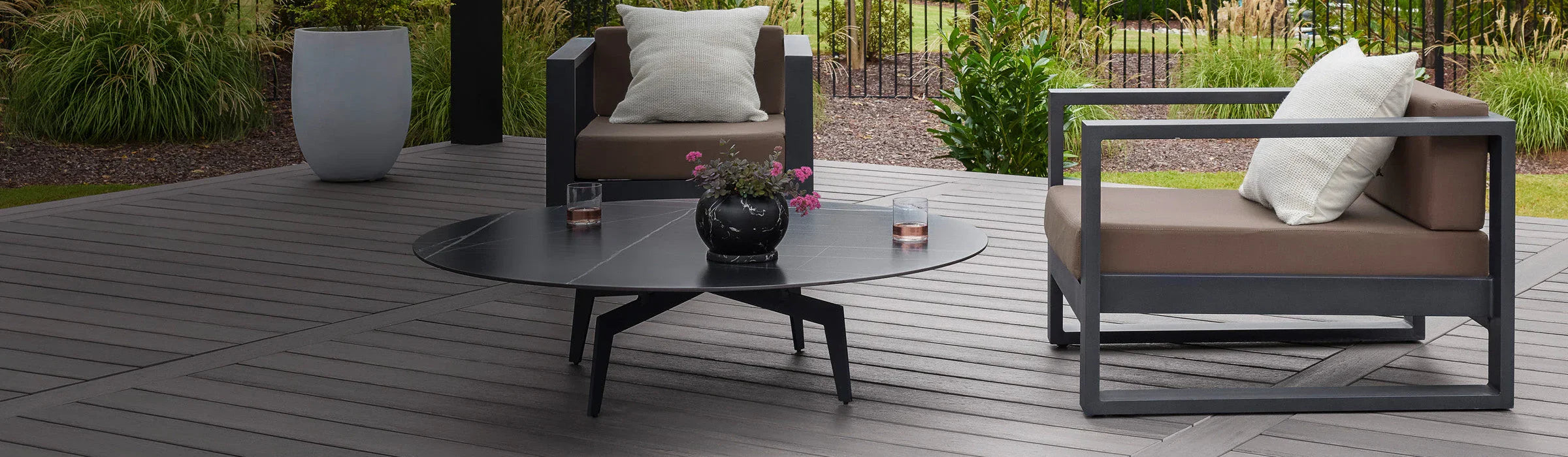 Terrasse en bois composite gris avec salon de jardin moderne et plantes décoratives
