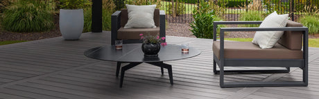 Terrasse en bois composite gris avec salon de jardin moderne et plantes décoratives