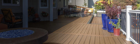 Terrasse en composite brun avec pots de fleurs colorés et mobilier de jardin, ambiance extérieure
