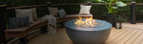 Terrasse en composite bois Timbertech avec foyer moderne, banquette et coussins décoratifs