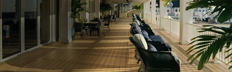 Terrasse en bois composite PVC brun avec fauteuils et tables, ambiance extérieure élégante