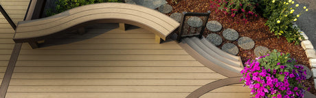 Terrasse en bois composite brun avec banc courbé, fleurs colorées et sentier de dalles